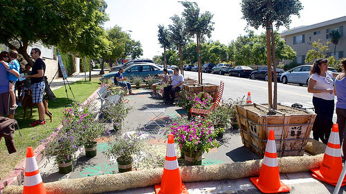 Pop up garden with bench seating on a street.