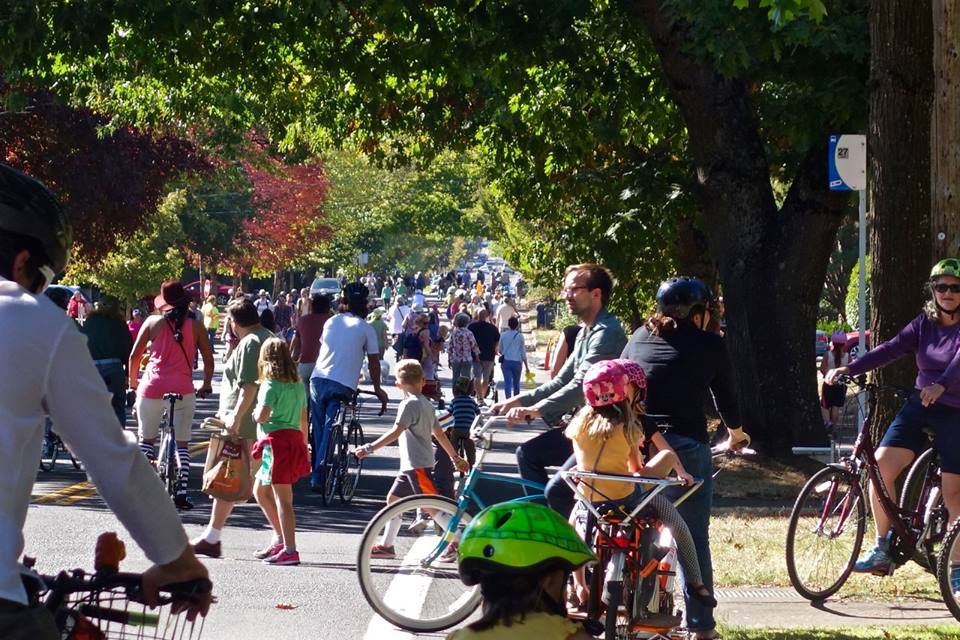 People walking and biking fill a street.