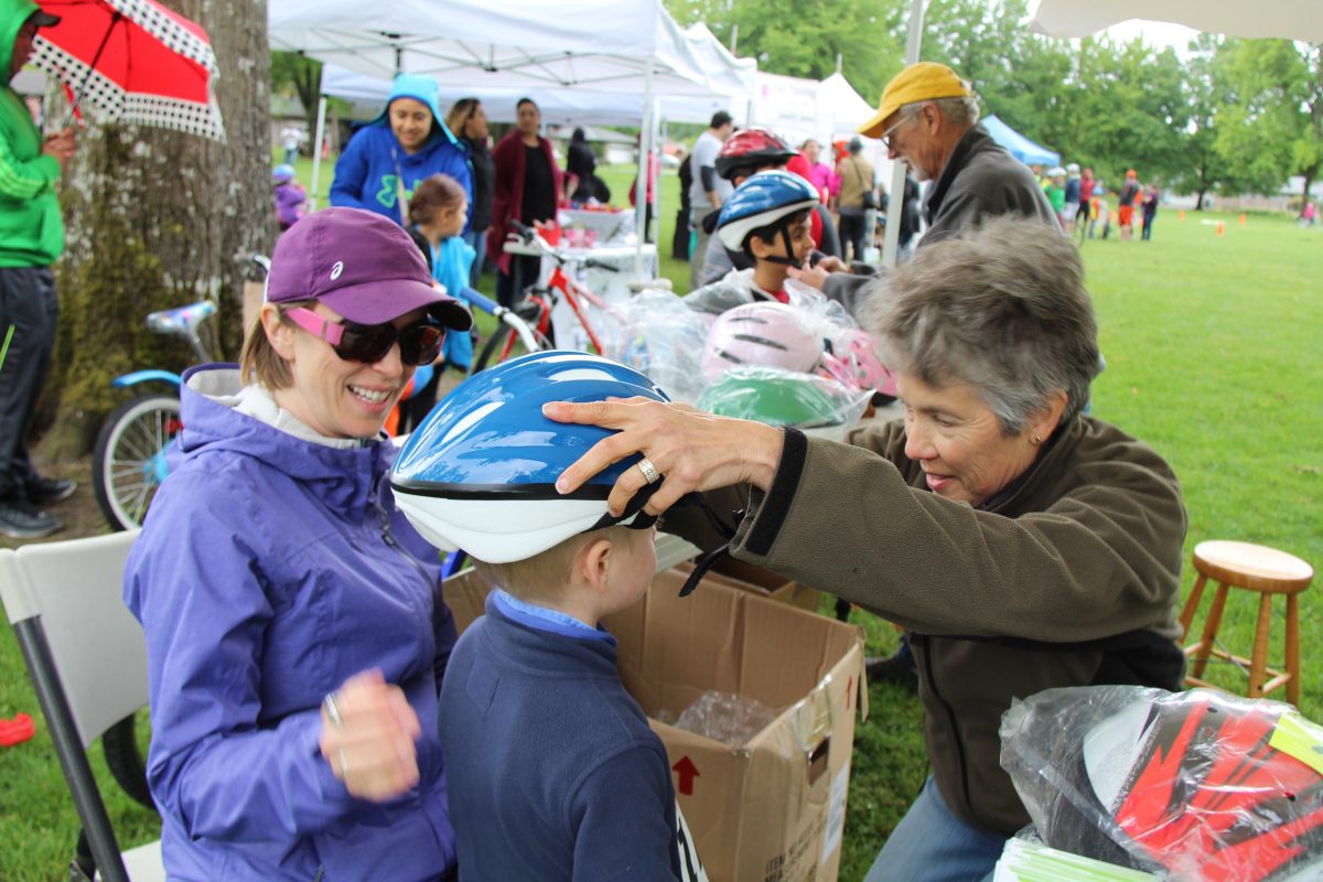 A child gets fitted for a new bicycle helmet.