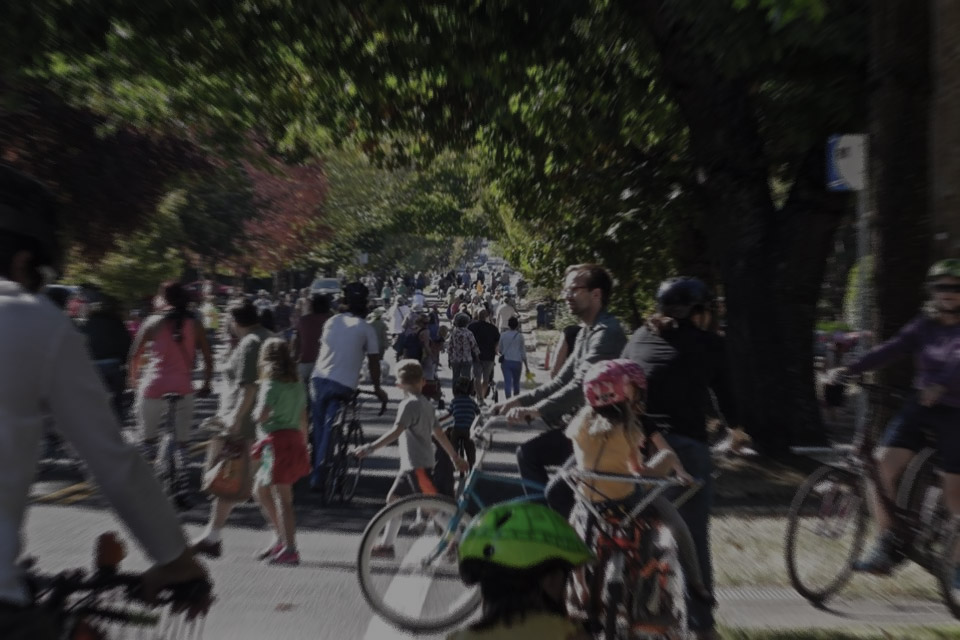 People fill the streets, walking and biking.