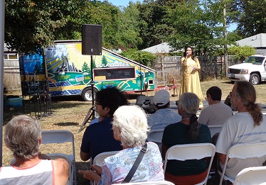 People seated listening to singer.