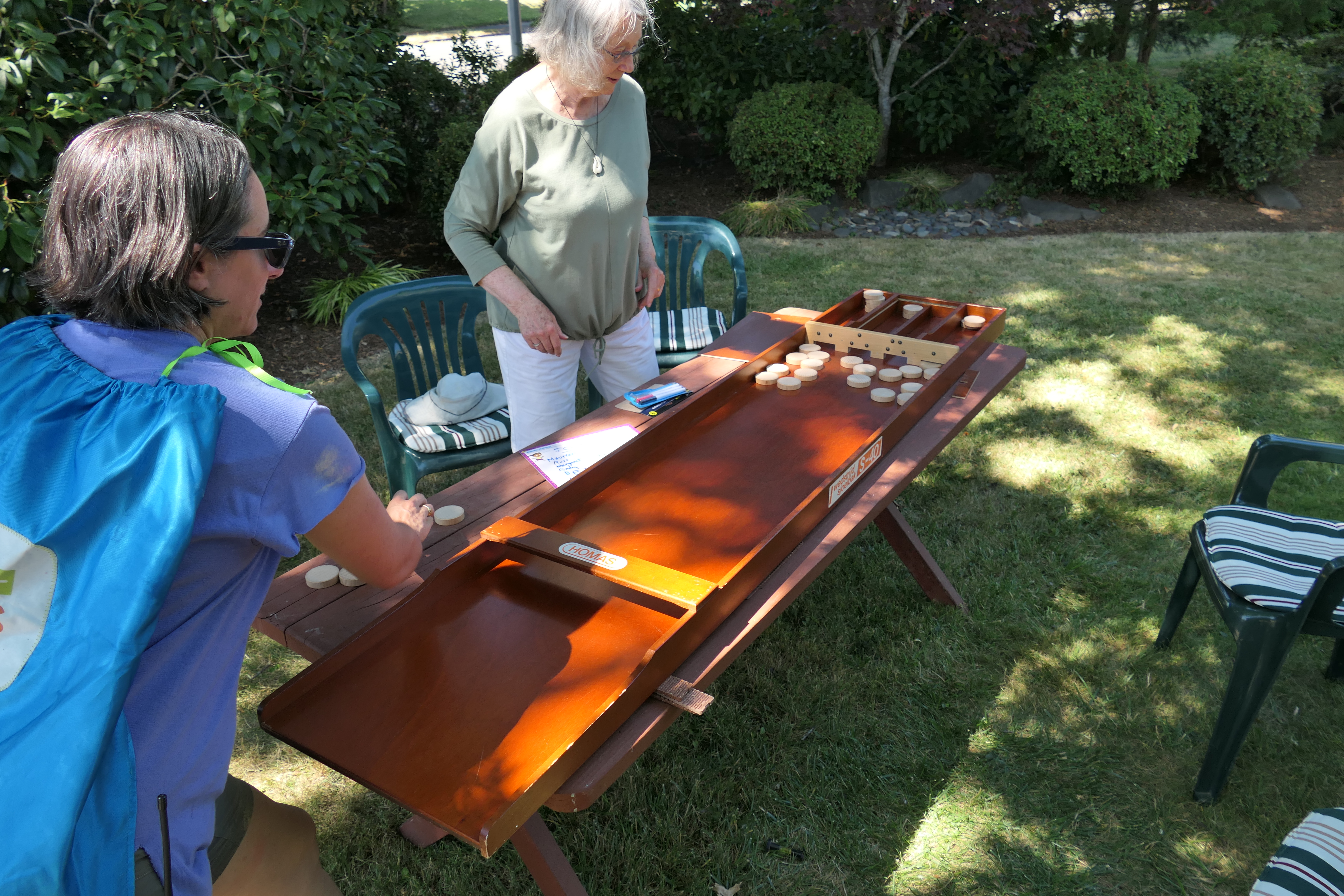 A woman plays a game in a neighbor's yard.