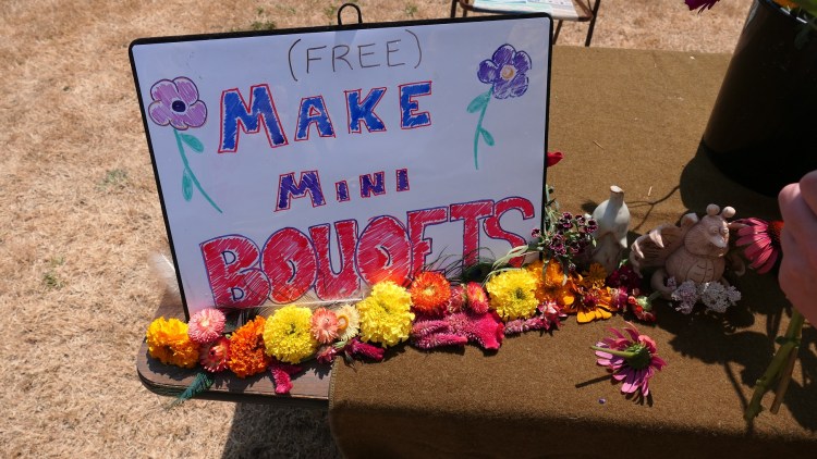 Table with flowers and a sign that says "Make Mini Bouquets"