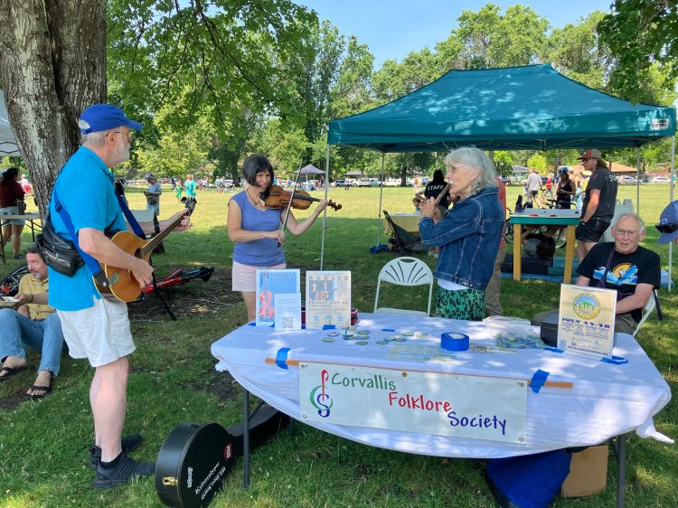 Musicians play music at the Corvallis Folklore Society booth