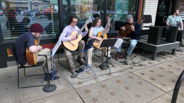 Guitar players perform in front of the Majestic Theatre