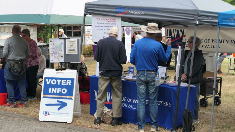 People stand in front of a booth that says "Voter Info"