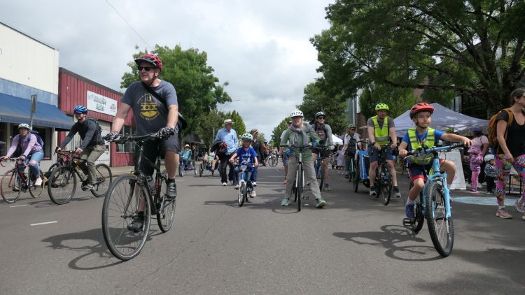 People of all ages bike in the parade