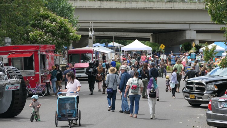 People walk down the event route toward the skate park