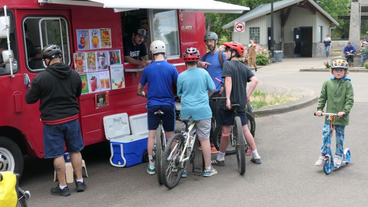 Cyclists wait in line at food truck