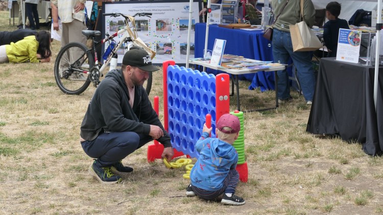 A parent and child play giant connect-4